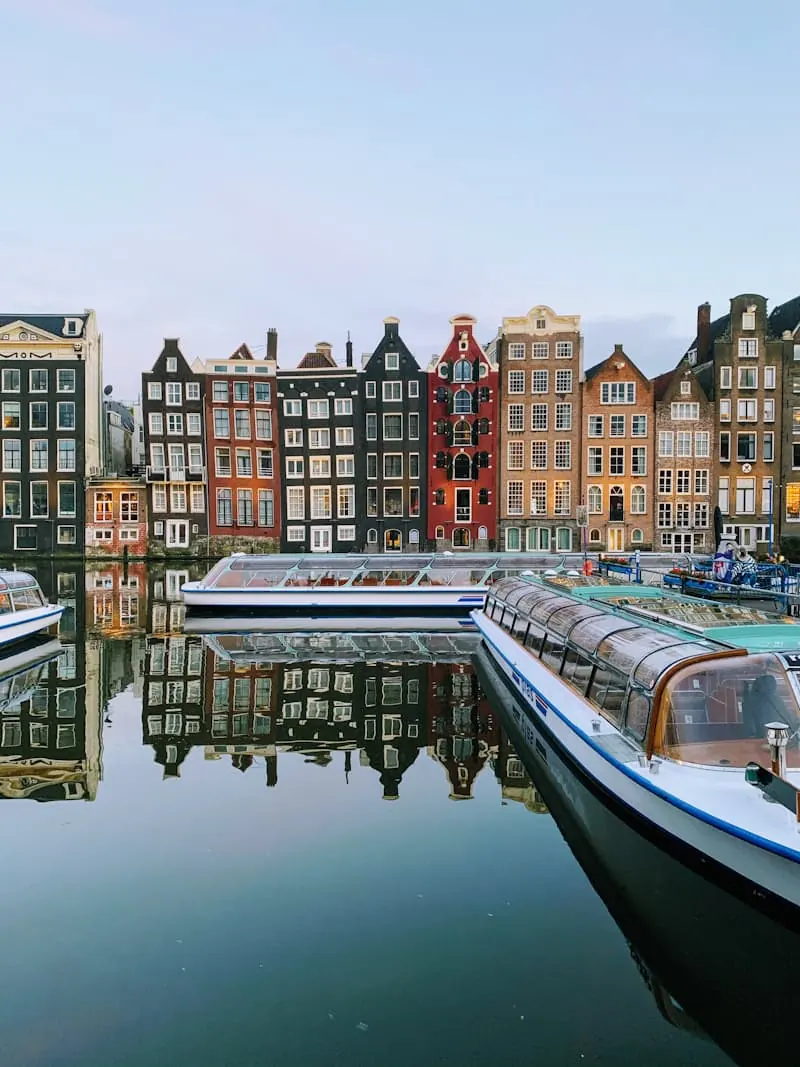 A boat passing beneath tall houses