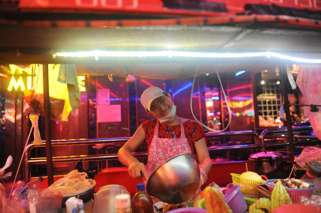 A cook mixing a bowl at a food counter